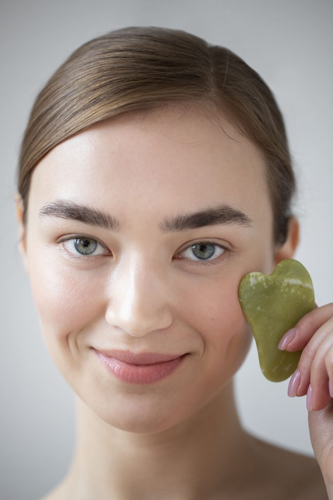 female with gua sha tool ready for massage 