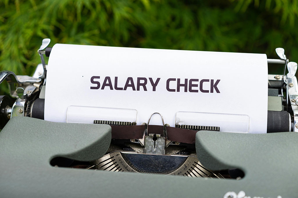 Typewriter with "SALARY CHECK" typed on paper.