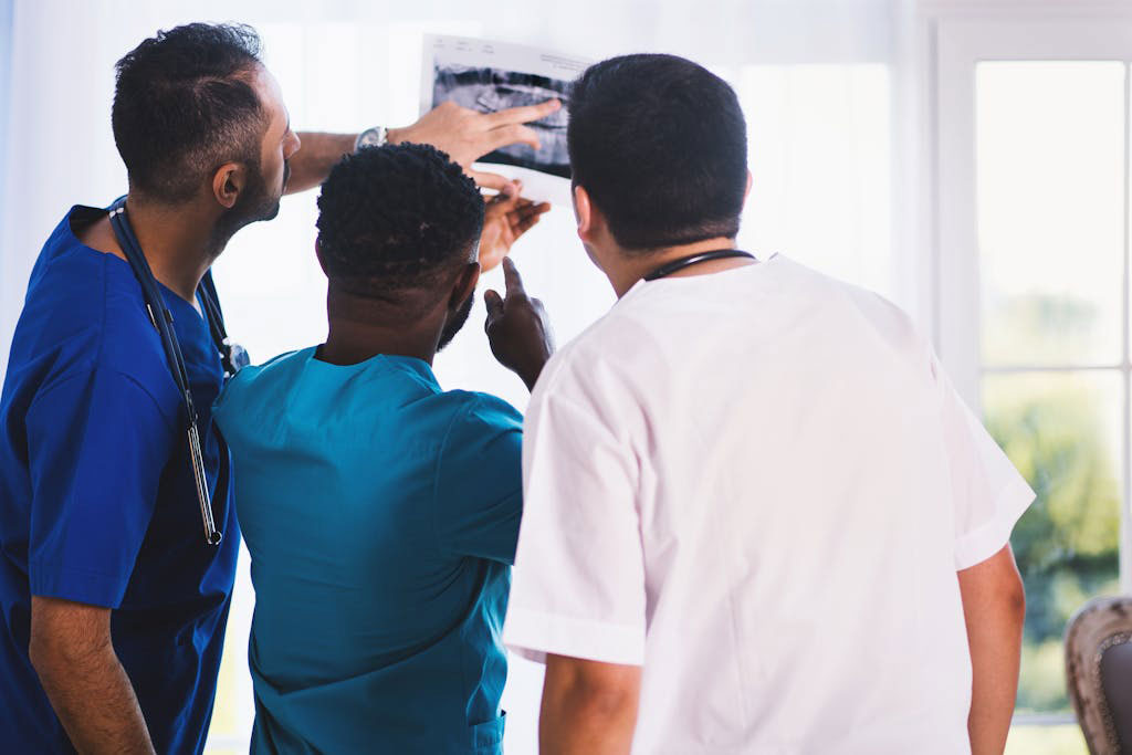 Three healthcare practitioners looking at X-Ray results